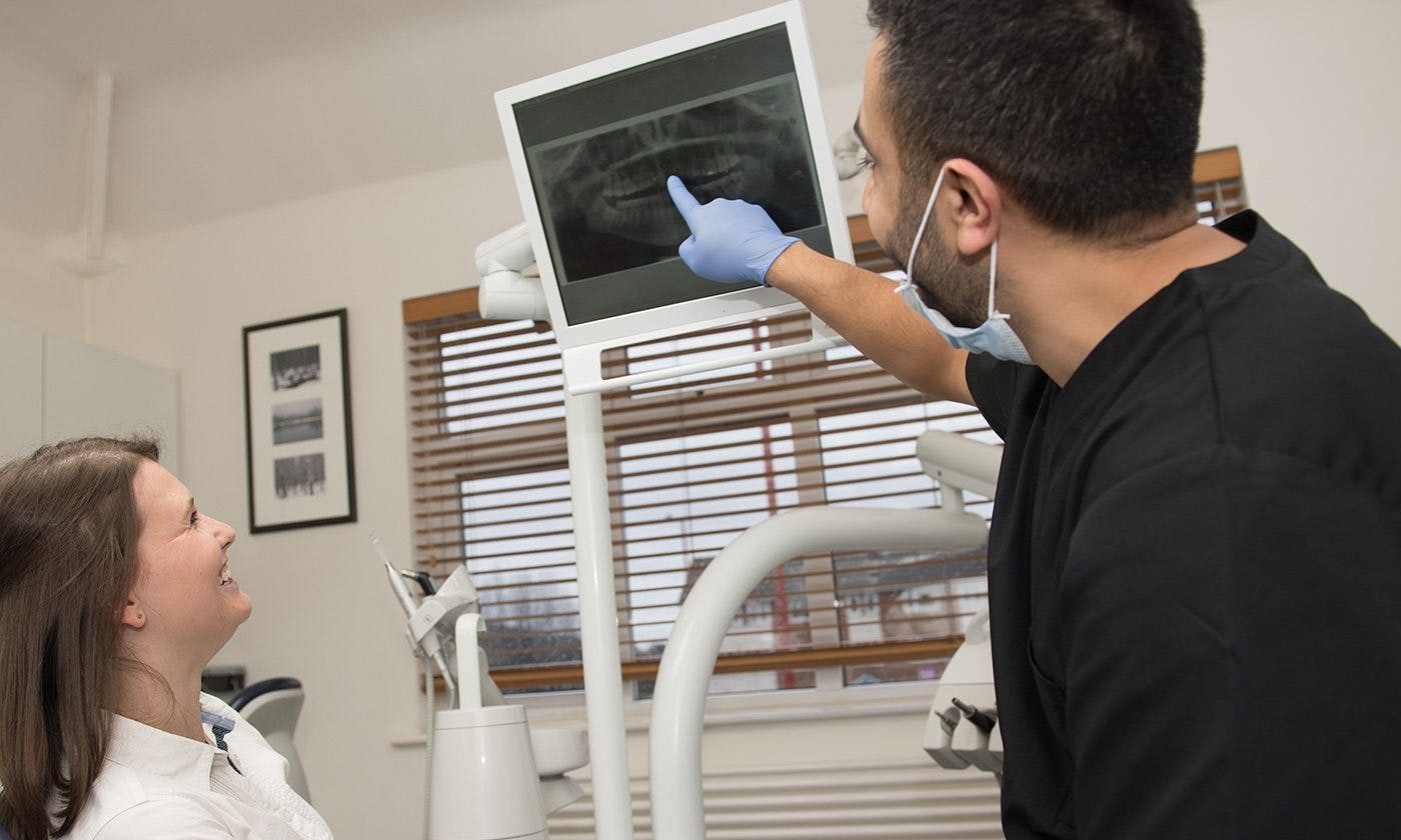 Dentist Pointing To Monitor