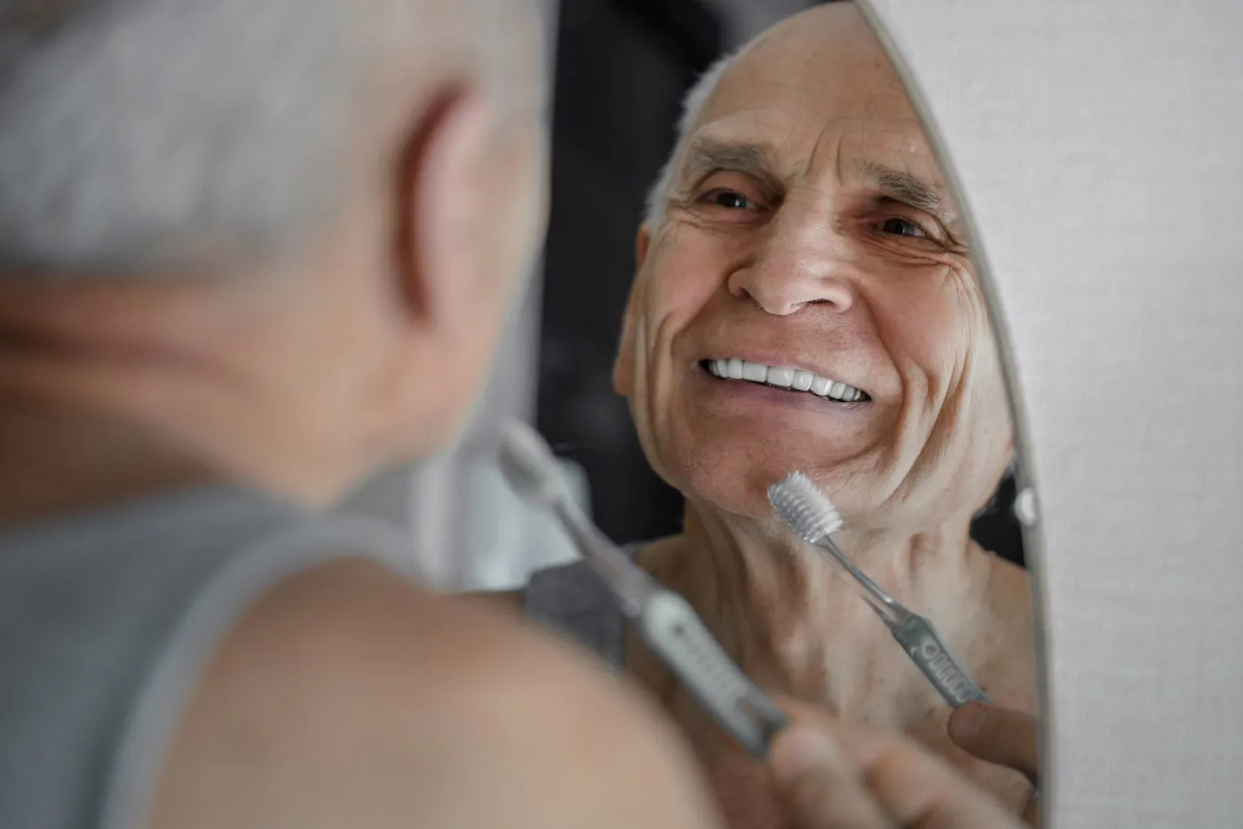 Man Smiling In Mirror Portman Dental Care Healthy Smile Healthy Heart